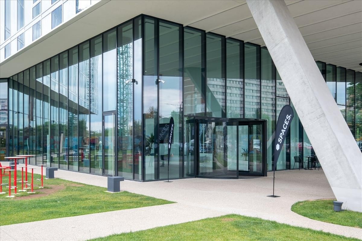 Exterior view of the glass entrance and modern facade at Campus 6. 1 Building.