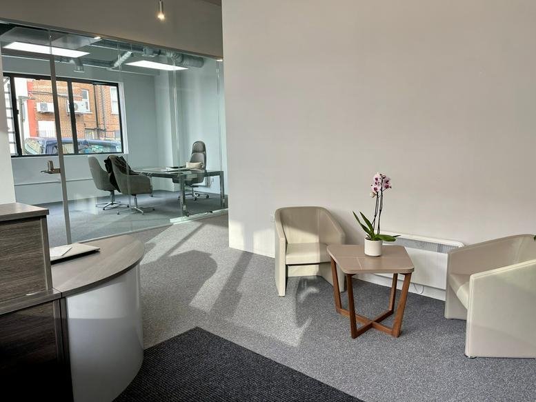 Bright reception and lounge area at 708 A High Road North with armchairs, a coffee table, and an orchid.