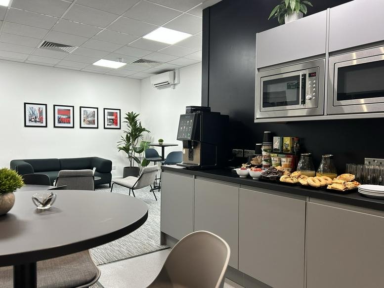 Communal break area at 71-75 Shelton Street with a coffee station, kitchen cabinets, and lounge seating.