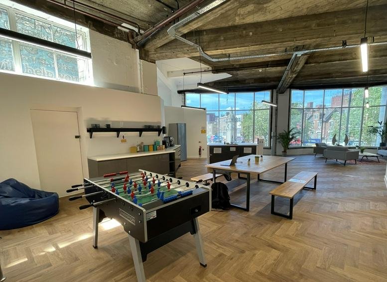Spacious communal breakout area at 71 Lewisham High Street with foosball table and high ceilings.