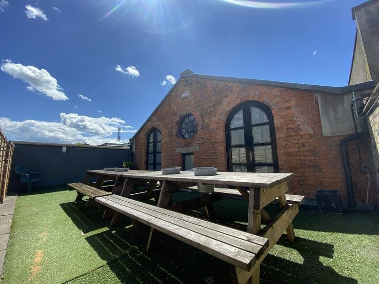 Exterior brick building at 79 Fitzwilliam Lane featuring arched windows and an outdoor picnic area.
