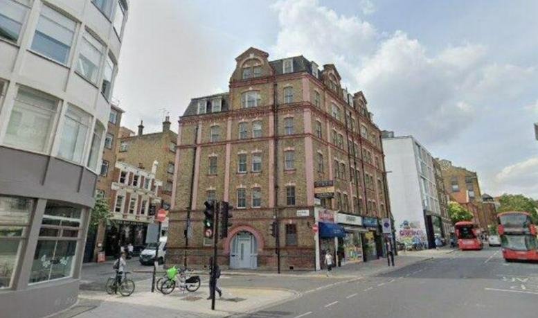 Exterior view of the historic brick building at 79, Saffron Hill, London on a street corner.