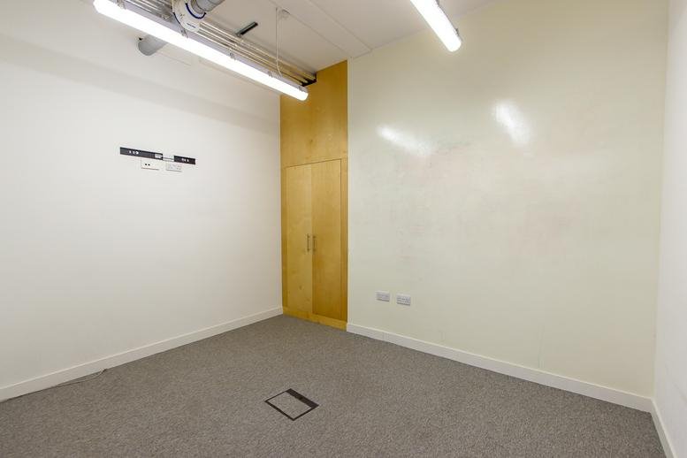 Small private office with white walls and a light wood storage cupboard.