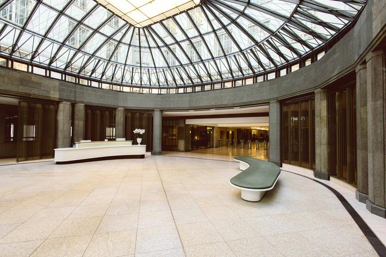 Grand lobby at 80 Strand, Central London, WC2R featuring a curved reception desk and glass dome roof.