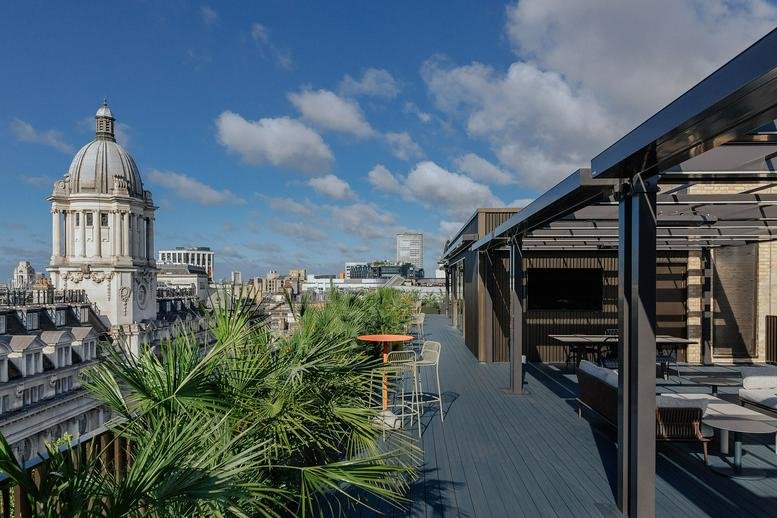 Rooftop terrace at 81-87 High Holborn with city views of a historic dome and lush greenery.