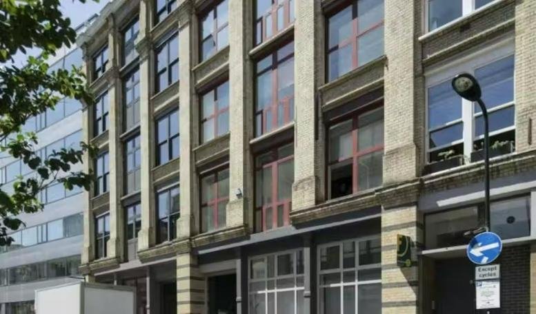 Exterior view of the historic brick and stone facade of the 83, Paul Street, London building.