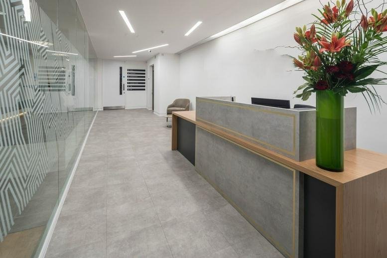 Reception area at 85 Great Eastern Street, Tech City, Old Street, London with a concrete desk and floral arrangement.