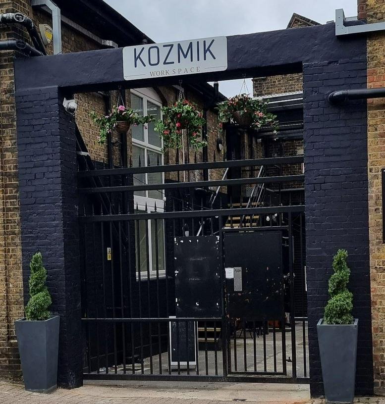 Exterior entrance and signage for 9-15 Elthorne Road, Unit 2c, with gated courtyard and spiral topiary.