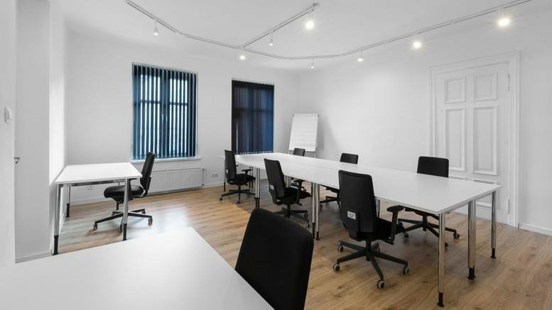 Meeting room at 9/4 Jaskowa Dolina Street, Gdansk featuring a large white table and ergonomic black chairs.