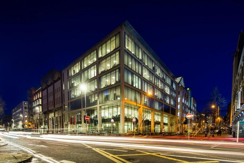 Exterior view of the glass-fronted Metro Office, 9 Donegall Square at dusk.