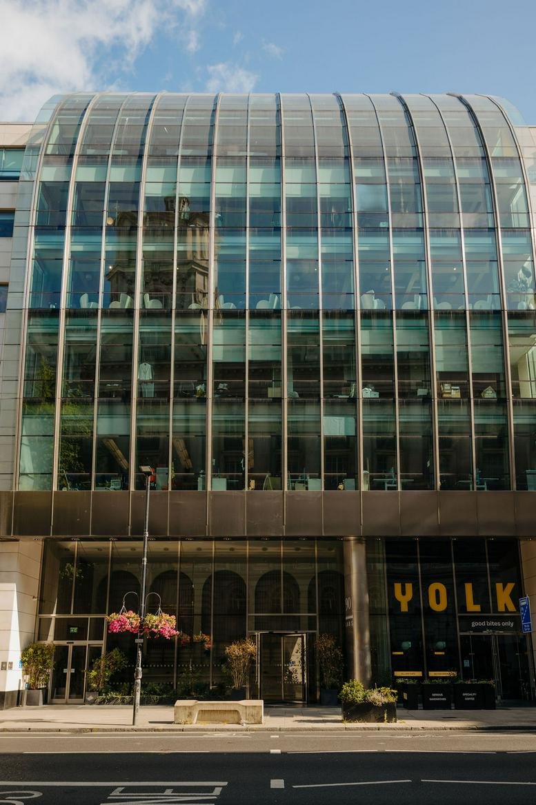 The modern curved glass facade of the 90 High Holborn building in London.