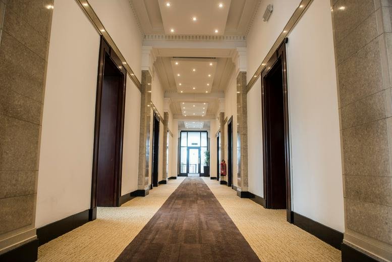 Grand hallway at 90 Watery Lane, Preston with high ceilings and polished stone columns.