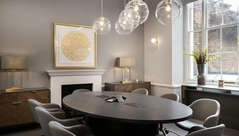 Sophisticated meeting room with an oval table and globe pendant lighting.