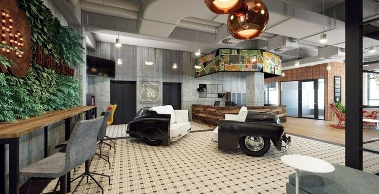 Bright lobby at Adgar PDT Wola, Ulica Mlynarska 8 with car-shaped sofas and copper pendant lights.