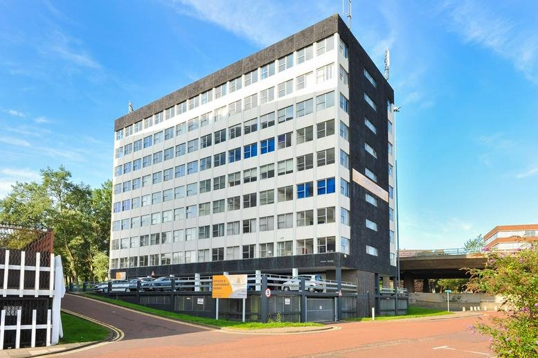 Exterior view of the multi-storey Aidan House building under a clear blue sky.