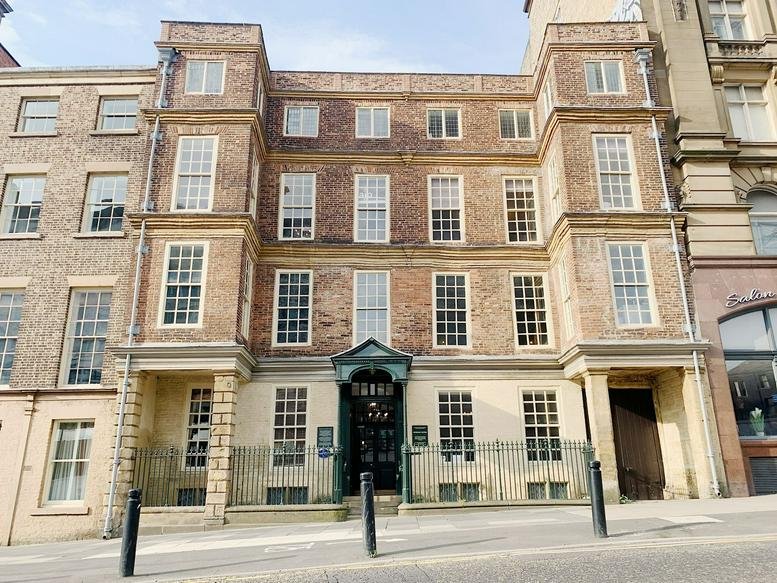 Exterior view of the historic brick facade of Alderman Fenwick’s House with its arched entrance.