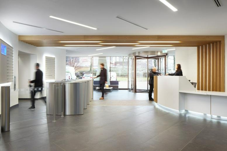 Spacious lobby at Alpha, Suffolk Street Queensway, with a wood-paneled ceiling and reception desk.