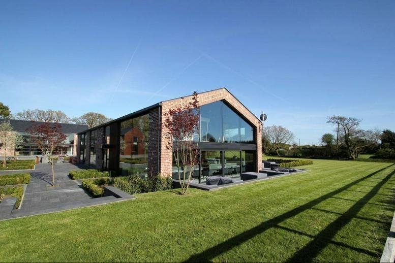 Exterior view of the brick and glass building at Altrincham Road, Morley, Wilmslow.