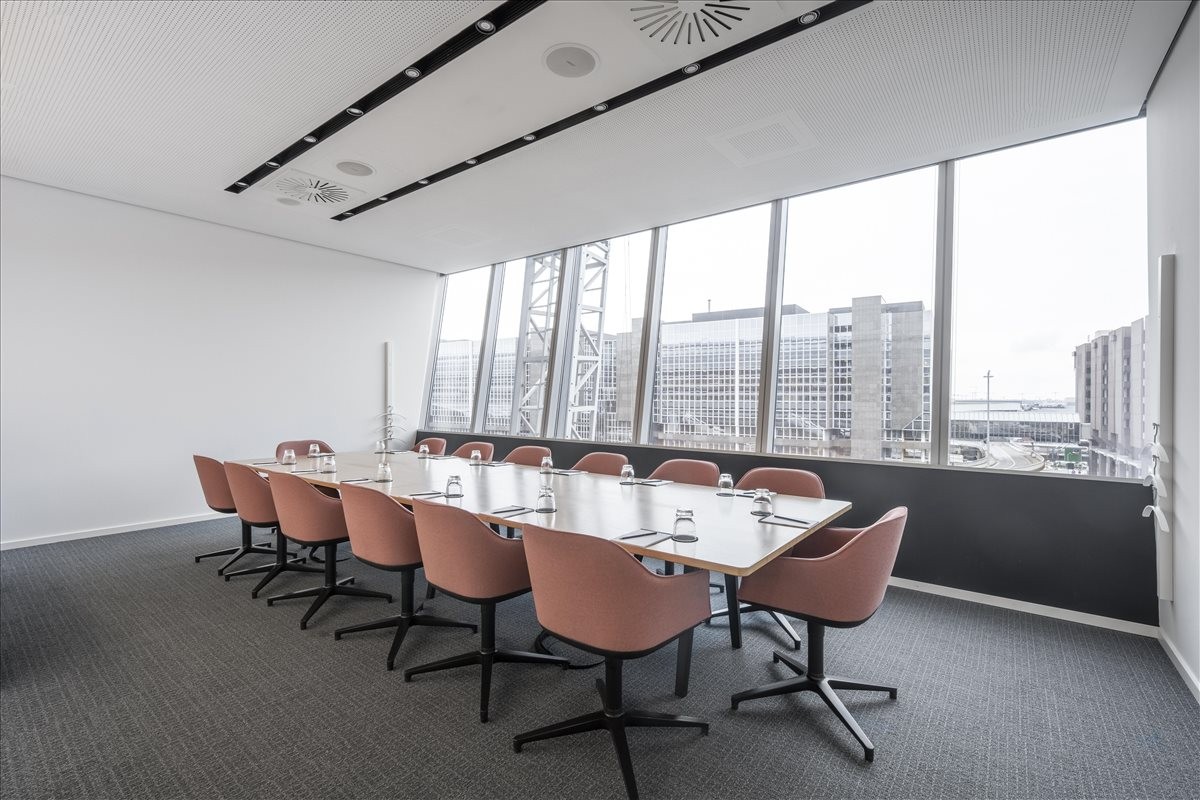 Spacious boardroom at Am Flughafen 12, 5th Floor, Frankfurt Airport with pink chairs and panoramic windows.