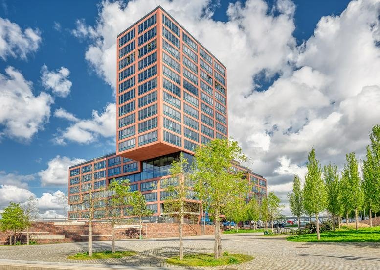 Exterior view of the modern, geometric brick and glass building at Amerigo Vespucci Platz 1.