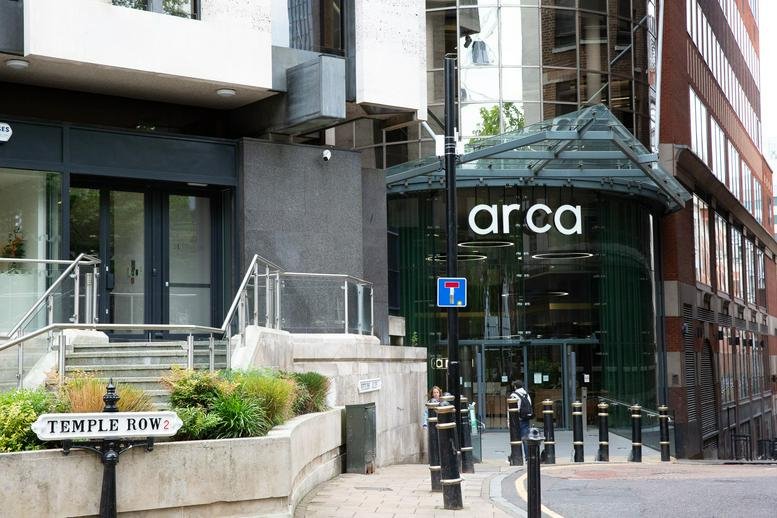 Exterior entrance of Arca, Temple Row showing the glass facade and modern signage.