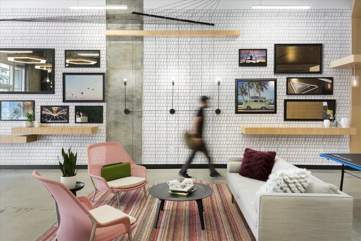 Spacious communal lounge at Avenida de Bruselas 7 featuring a gallery wall, soft seating, and a large area rug.