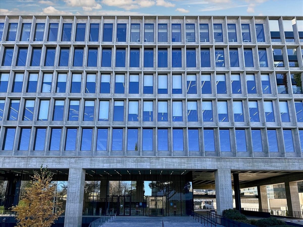 Exterior facade of the glass and concrete office building at Avenida de Manoteras 12.