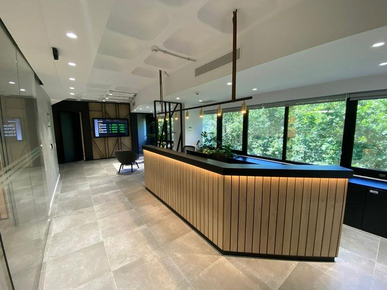 Modern wood-paneled reception desk with integrated warm LED lighting.