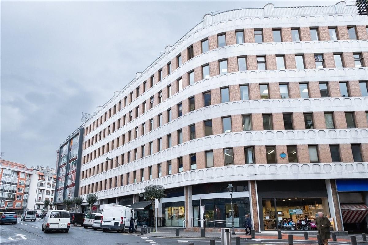 Exterior of the curved white stone and brick building at Avenida Madariaga 1.