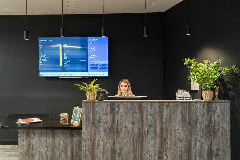 Timber-clad reception desk at Avenue HQ, 4 St Paul's Square with a digital display wall.