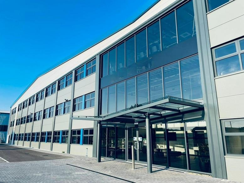 Modern exterior of Aviation Park West on Target Road featuring a glass entrance and sleek grey cladding.