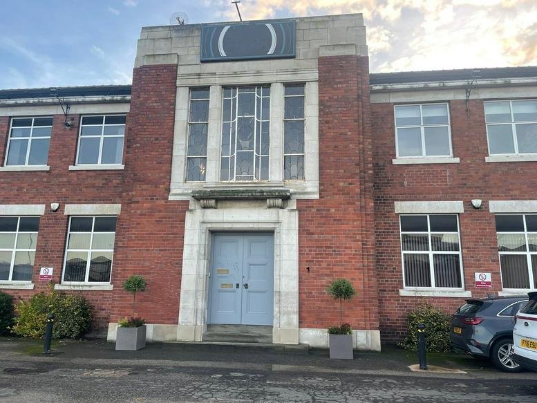 Red brick exterior facade and entrance of the Balby Court Business Campus with large architectural windows.
