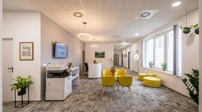 Spacious reception area at Barna street 23 with yellow lounge seating, plants, and modern lighting.