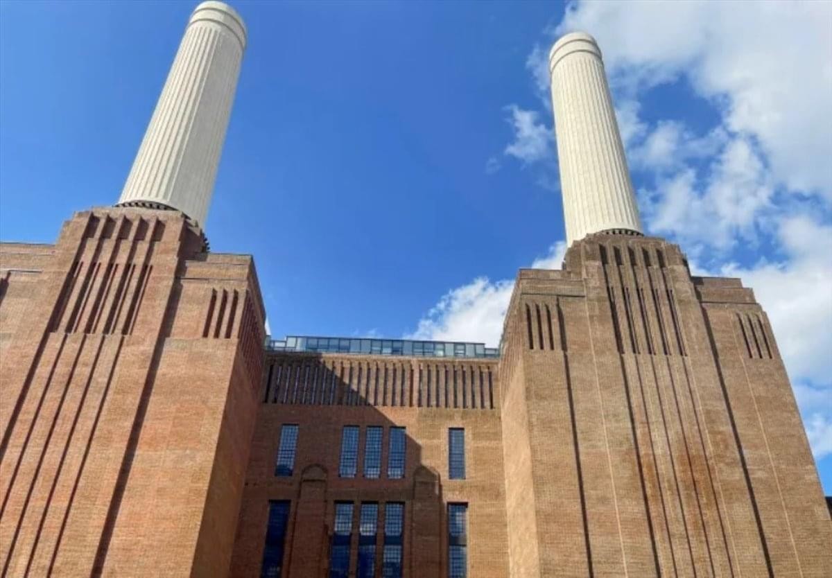 Exterior view of the iconic brick facade and white chimneys at Battersea Power Station, 18 The Power Station.