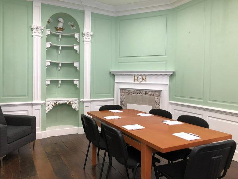 Elegant meeting room at Bearland Lodge, 45-47 Longsmith Street featuring mint green wood panelling and a fireplace.