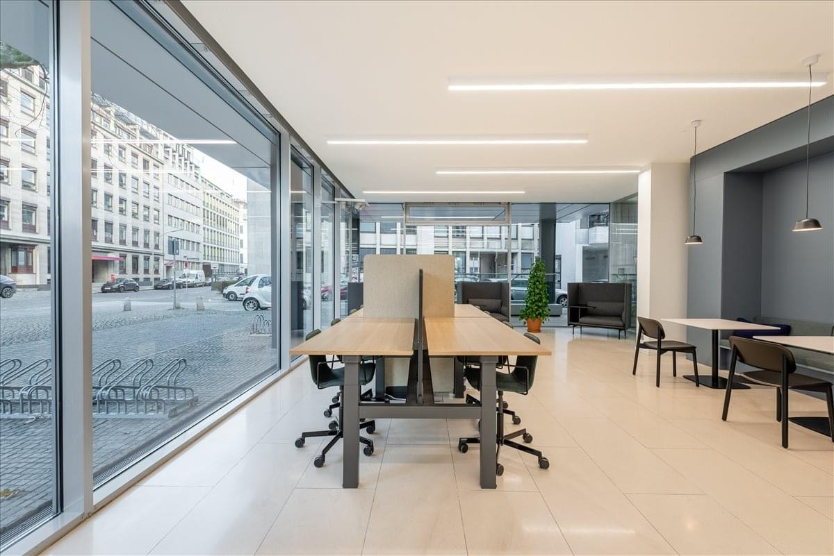 Spacious open-plan workspace at Bei den Mühren 1 featuring natural light and city views.