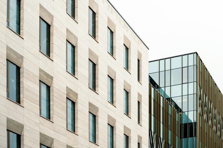 Exterior view of the modern stone and glass facade of Bem József Utca 1/B, Budapest.