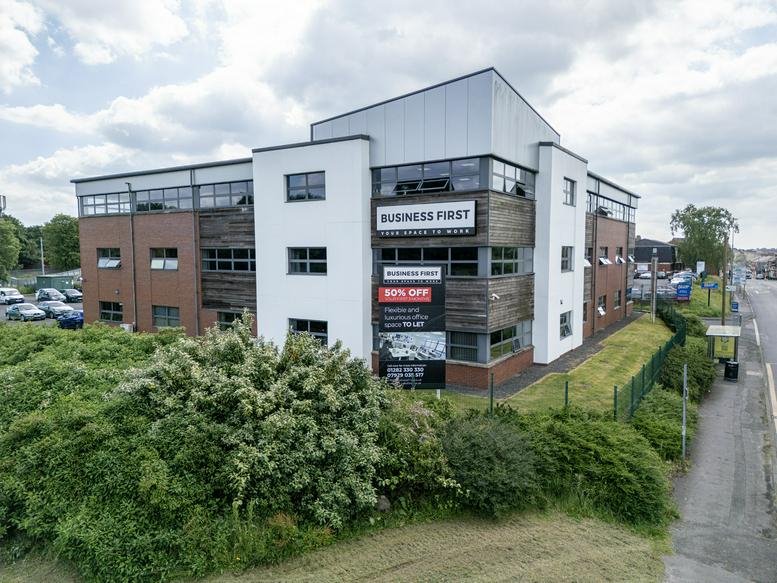 Full exterior view of the multi-storey business centre under a cloudy sky.