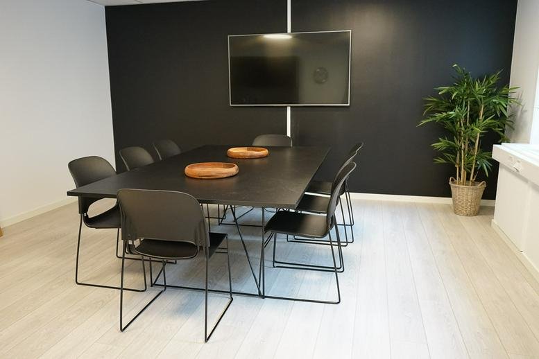 Contemporary meeting space at Bogstadveien 27B, Oslo, Norway with a black table and dark feature wall.