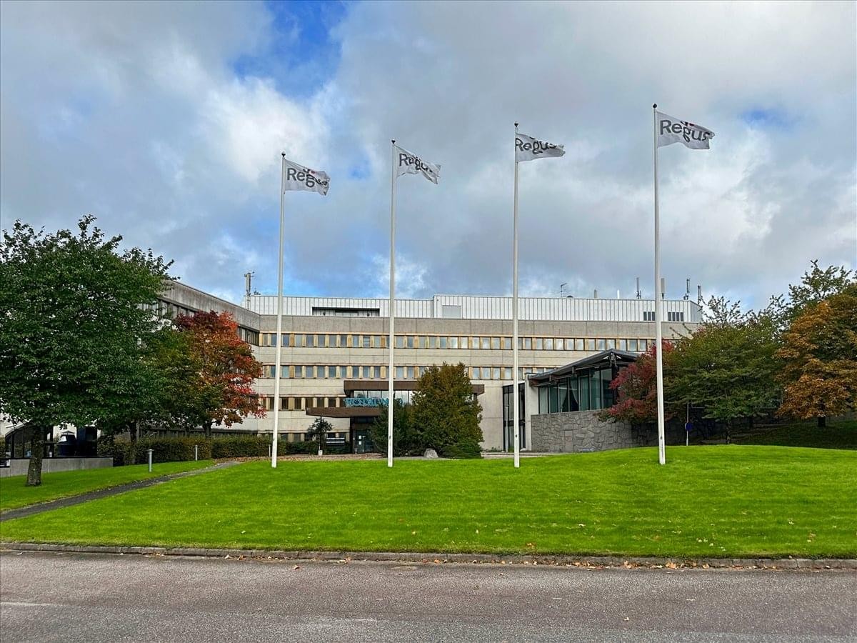 Exterior view of the multi-story office building at Bollstanäsvägen 3 with white flagpoles.