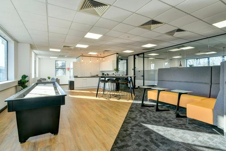 Spacious open-plan workspace at Bonville House, Blackbrook Business Park, featuring a games table and lounge area.