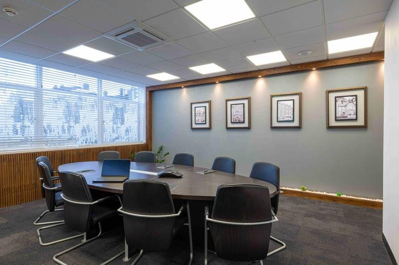 Spacious boardroom at Boundary House, Boston Road, Hanwell with an oval table and framed wall art.