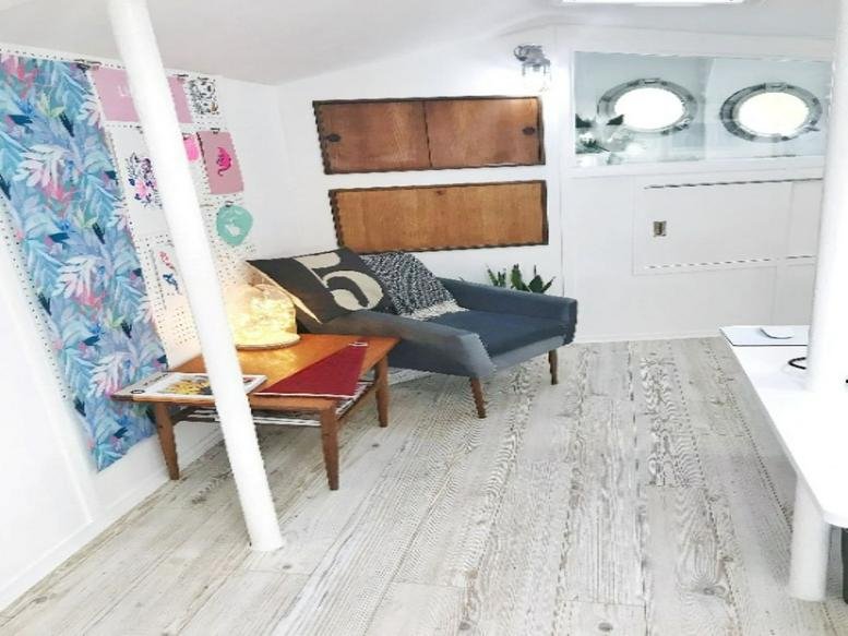 Bright workspace at Bow Office, Lightship 95, featuring a modern grey sofa and colorful wall art.