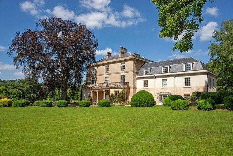 Exterior view of the historic Georgian-style Box House, Bath Road, Corsham surrounded by lush green lawns.