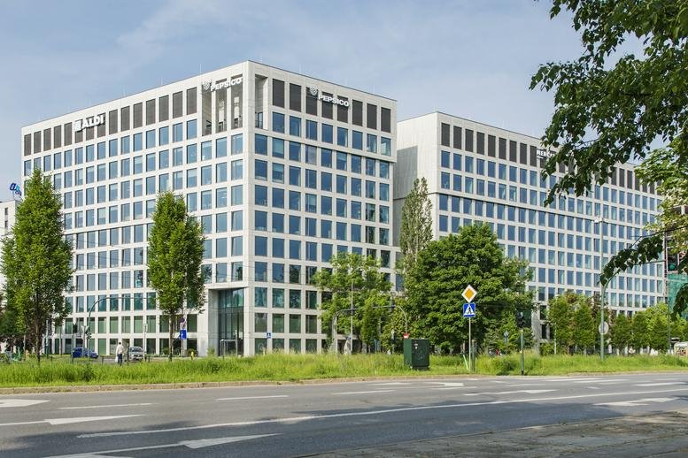 Exterior view of the modern white grid-facade buildings at Brain Park, Fabryczna 1.