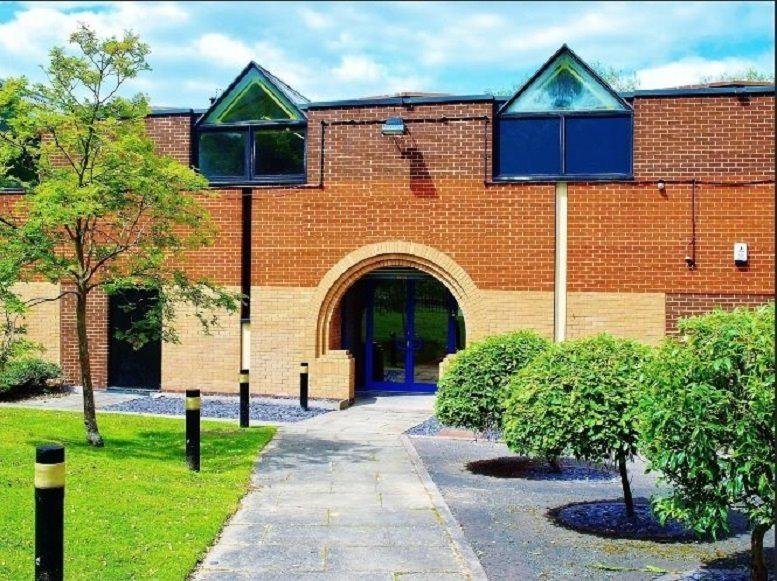 Exterior of Unit 1 Pepper Road, Bramhall Moor Industrial Estate featuring a red brick facade and arched entrance.