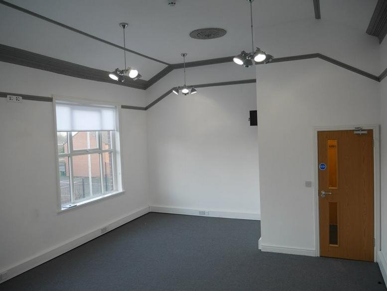 Spacious, well-lit meeting room at Brighton House, Turks Road, Radcliffe with tall windows and modern lighting.