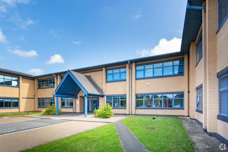 Exterior view of the brick facade and blue gabled entrance at Britannia House.