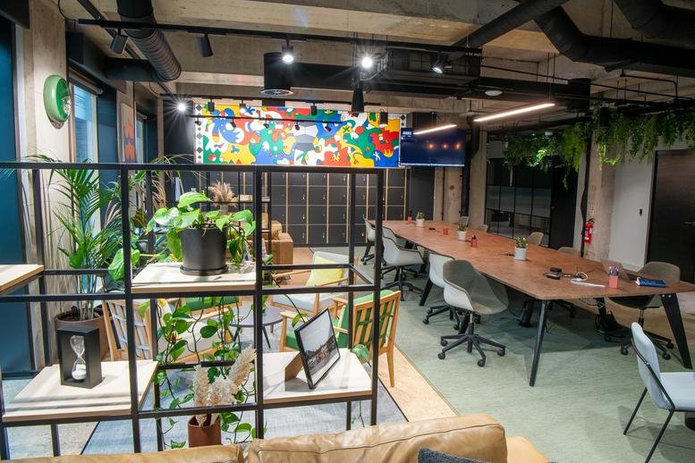 Vibrant coworking space with a mix of desk seating, lounge areas, and a colourful mural.