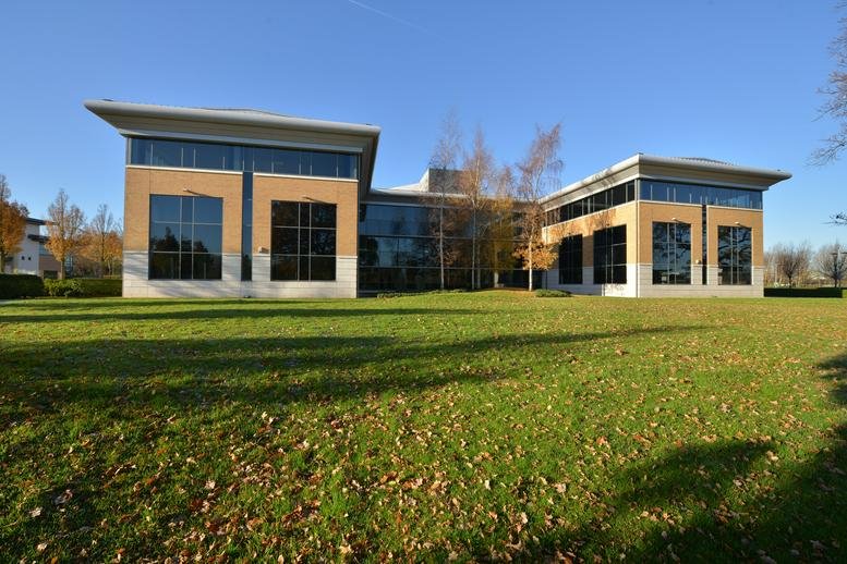 Exterior view of the modern brick and glass building at Brooks Drive, Cheadle Royal Business Park.